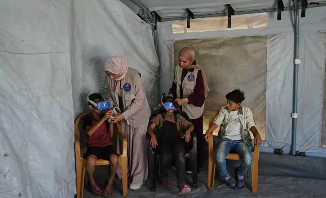 Palestinian children participate in a psychological support session using a virtual reality headset in a tent operated by a medical technology team in Zawaida, central Gaza Strip, Wednesday, June 17, 2026. (AP Photo/Abdel Kareem Hana)