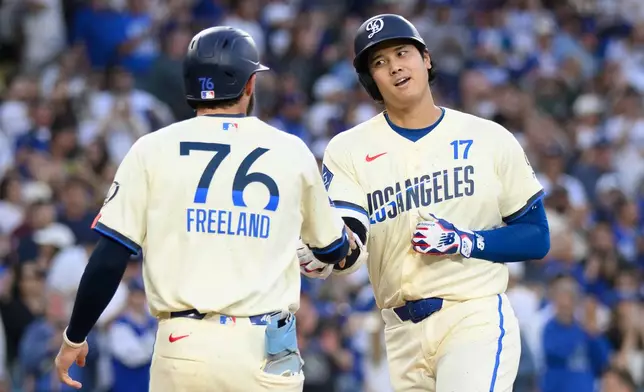 Los Angeles Dodgers' Shohei Ohtani, right, celebrates his two-run home run with Alex Freeland during the first inning of a baseball game against the Los Angeles Angels in Los Angeles, Saturday, June 6, 2026. (AP Photo/Kyusung Gong)
