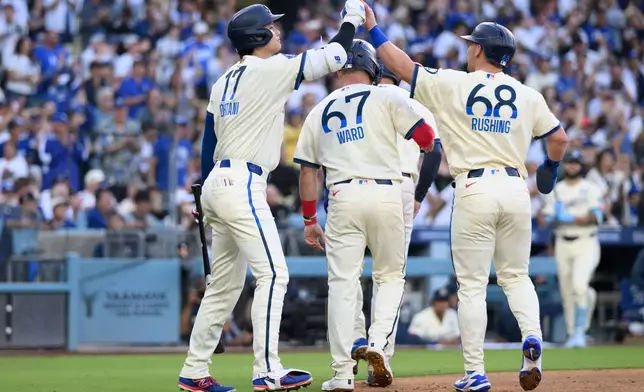 Los Angeles Dodgers' Shohei Ohtani, left, greets Dalton Rushing, right, after Rushing scores during the first inning of a baseball game against the Los Angeles Angels in Los Angeles, Saturday, June 6, 2026. (AP Photo/Kyusung Gong)