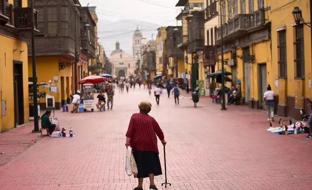 A woman walks through the Rimac district in Lima, Peru, Monday, June 8, 2026, a day after the presidential election runoff. (AP Photo/Rodrigo Abd)