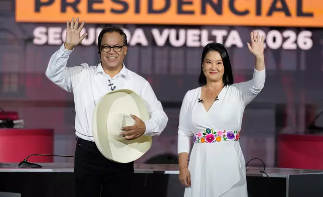 Presidential candidate Keiko Fujimori of the Popular Force party and her rival Roberto Sanchez of Together for Peru party wave during a presidential debate, in Lima, Peru, Sunday, May 31, 2026. (AP Photo/Martin Mejia)