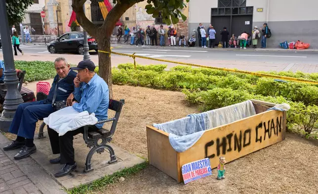 Men sit at a park in Lima, Peru, Monday, June 8, 2026, the day after the presidential election runoff. (AP Photo/Rodrigo Abd)