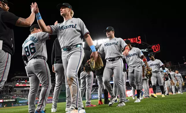 Miami Marlins players greet each other after defeating the Washington Nationals in a baseball game, Tuesday, June 2, 2026, in Washington. (AP Photo/Terrance Williams)