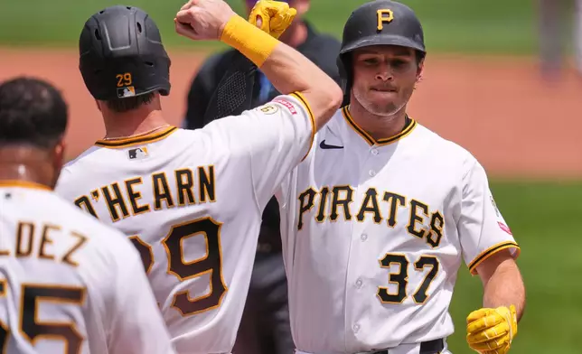 Pittsburgh Pirates' Tyler Callihan (37) celebrates with Ryan O'Hearn (29) as he crosses home plate after hitting a three-run home run off Cincinnati Reds pitcher Brady Singer during the second inning of a baseball game in Pittsburgh, Sunday, June 28, 2026. (AP Photo/Gene J. Puskar)