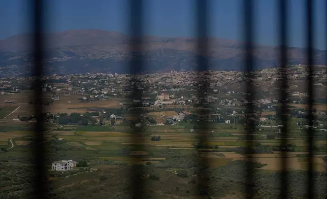 The southern town of Khiam, Lebanon, is seen through a fence near the Lebanon-Israel border, Wednesday, June 10, 2026. (AP Photo/Hassan Ammar)