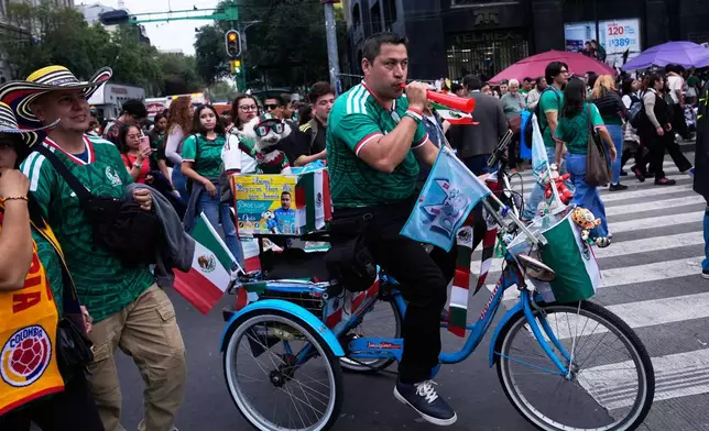 Jorge Rangel rides a bicycle accompanied by his dog, Osito, both wearing Mexico national team jerseys before their World Cup match against South Korea in Mexico City, Thursday, June 18, 2026. (AP Photo/Marco Ugarte)