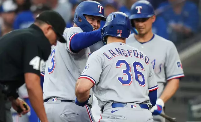 Texas Rangers' Wyatt Langford (36) celebrates his three-run home run against the Toronto Blue Jays with Joc Pederson (3) during the third of a baseball game in Toronto, Thursday, June 25, 2026. (Nathan Denette/The Canadian Press via AP)