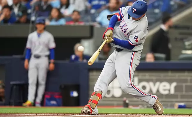 Texas Rangers designated hitter Joc Pederson (3) hits a solo home run against the Toronto Blue Jays during the first inning of a baseball game in Toronto, Thursday, June 25, 2026. (Nathan Denette/The Canadian Press via AP)