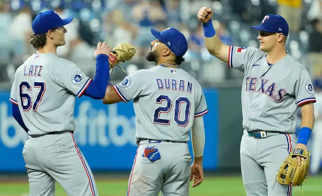 Texas Rangers' Jacob Latz (67) Ezequiel Duran (20) and Josh Jung, right, celebrate after their baseball game against the Kansas City Royals, Wednesday, June 10, 2026, in Kansas City, Mo. (AP Photo/Charlie Riedel)