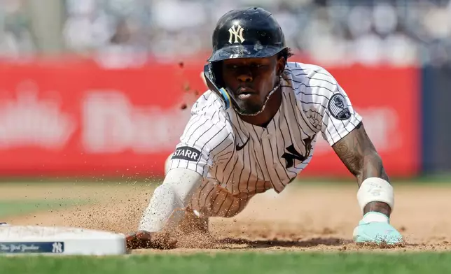 New York Yankees' Jazz Chisholm Jr. dives safely back to first base during the seventh inning of a baseball game against the Cleveland Guardians, Thursday, June 4, 2026, in New York. (AP Photo/Adam Hunger)