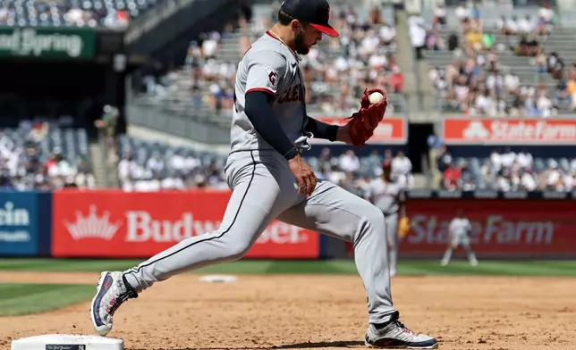 Cleveland Guardians pitcher Slade Cecconi checks his glove for the ball after getting a force out on New York Yankees' Ryan McMahon at first base during the fifth inning of a baseball game Thursday, June 4, 2026, in New York. (AP Photo/Adam Hunger)