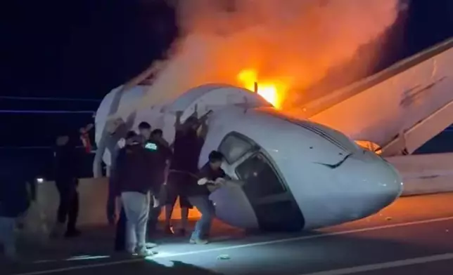 People attempt to pull passengers out of a plane after it crashed on a highway Tuesday, June 16, 2026, in Laredo, Texas. (Zayra Garza via AP)
