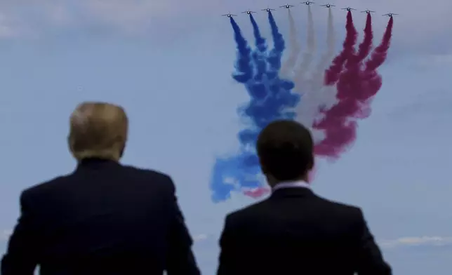 FILE - President Donald Trump, left, and French President Emmanuel Macron watch a flyover during a ceremony to commemorate the 75th anniversary of D-Day at the American Normandy cemetery, June 6, 2019, in Colleville-sur-Mer, Normandy, France. (AP Photo/Alex Brandon, File)