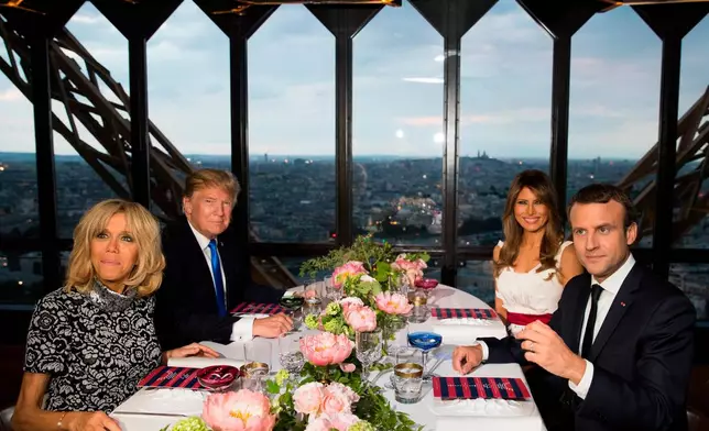 FILE - In this July 13, 2017 file photo, President Donald Trump, first lady Melania Trump, French President Emmanuel Macron, right, and his wife Brigitte Macron, left, sit for dinner at the Jules Verne Restaurant at the Eiffel Tower in Paris. (AP Photo/Carolyn Kaster, File)