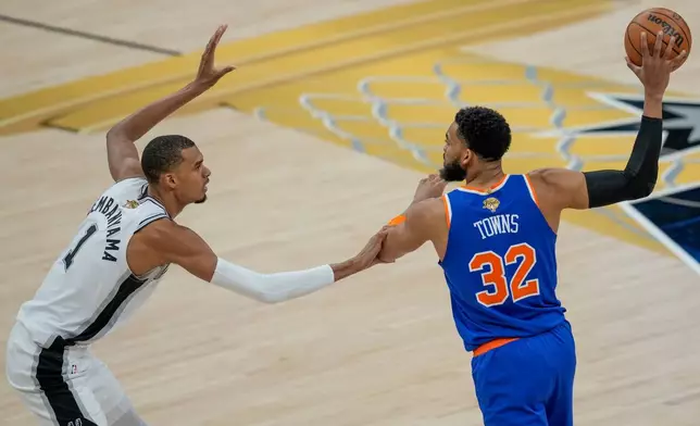 San Antonio Spurs forward Victor Wembanyama (1) defends against New York Knicks center Karl-Anthony Towns (32) during the first half of Game 2 of the NBA Finals basketball series, Friday, June 5, 2026, in San Antonio. (AP Photo/David J. Phillip)