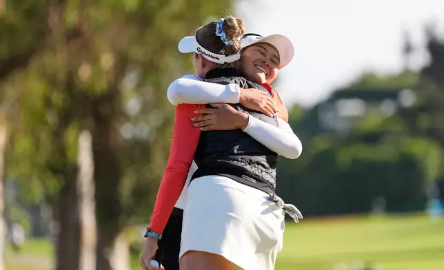 Sora Kamiya, of Japan, facing, hugs Nelly Korda after finishing the day on the 18th green during the third round of the U.S. Women's Open golf tournament Saturday, June 6, 2026, in the Pacific Palisades area of Los Angeles. (AP Photo/Ashley Landis)