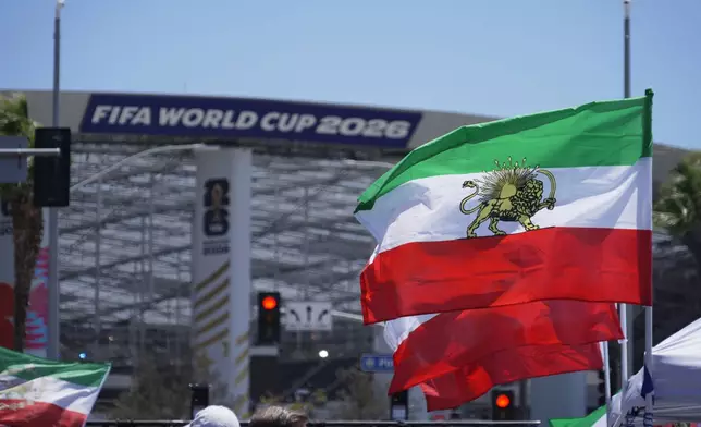Pre-revolutionary Iranian flags stand during a protest outside Los Angeles Stadium before the World Cup Group G soccer match between Iran and New Zealand in Inglewood, Calif., near Los Angeles, Monday, June 15, 2026. (AP Photo/Ty ONeil)