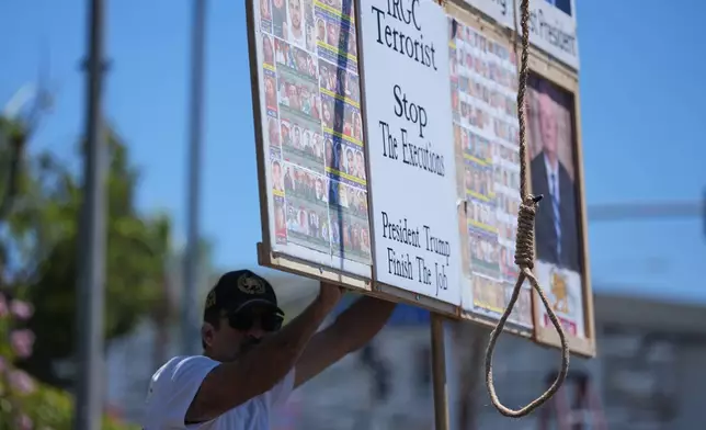A protester holds a sign with a noose outside Los Angeles Stadium before the World Cup Group G soccer match between Iran and New Zealand in Inglewood, Calif., near Los Angeles, Monday, June 15, 2026. (AP Photo/Jae C. Hong)