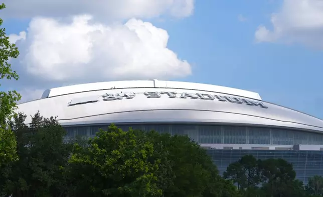 Workers cover signage on the exterior of AT&amp;T Stadium, which will be named Dallas Stadium during the 2026 FIFA World Cup soccer tournament, as preparations continue at the venue, Tuesday, June 2, 2026, in Arlington. (AP Photo/LM Otero)