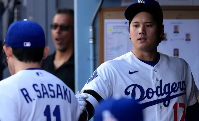Los Angeles Dodgers starting pitcher Roki Sasaki, left, greets Shohei Ohtani I. The dugout prior to a baseball game against the Los Angeles Angels, Friday, June 5, 2026, in Los Angeles. (AP Photo/Mark J. Terrill)