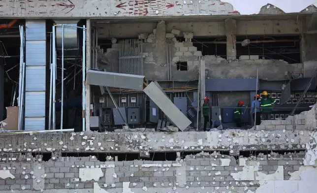 Workers inspect a damaged mall in General Santos, southern Philippines, Thursday, June 11, 2026, following Monday's powerful earthquake. (AP Photo/Basilio Sepe)