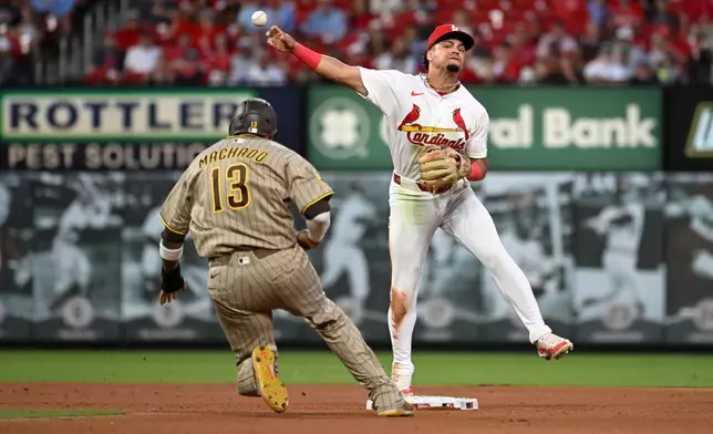 San Diego Padres' Manny Machado (13) is out at second base as St. Louis Cardinals shortstop Masyn Winn, right, turns a double play in the seventh inning of a baseball game, Monday, June 15, 2026, in St. Louis. (AP Photo/Joe Puetz)