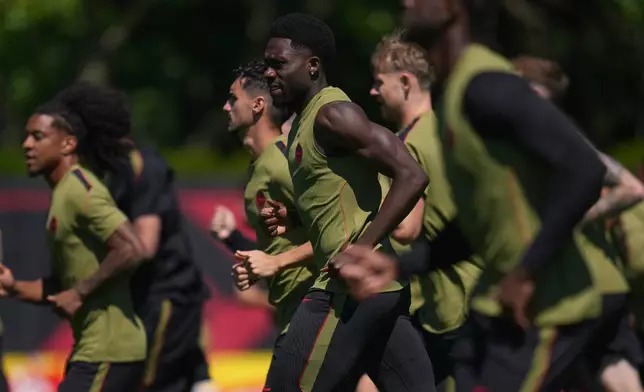Canada's Alphonso Davies, middle, works out during a training session on the eve of the team's World Cup soccer match against Qatar, Wednesday, June 17, 2026, in Vancouver, British Columbia. (AP Photo/Abbie Parr)