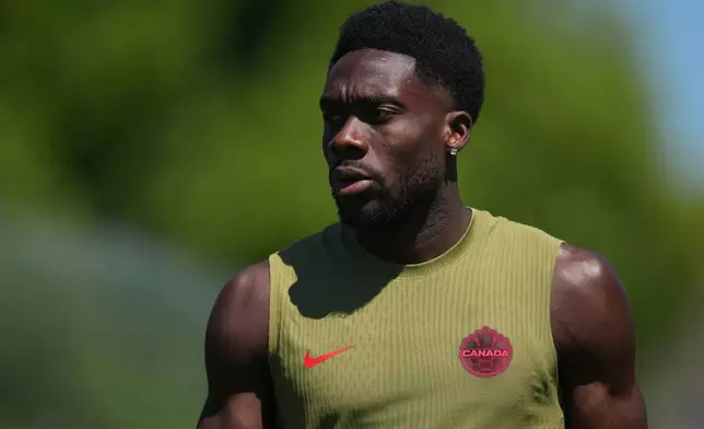 Canada's Alphonso Davies walks across the field during a training session on the eve of the team's World Cup soccer match against Qatar, Wednesday, June 17, 2026, in Vancouver, British Columbia. (AP Photo/Abbie Parr)