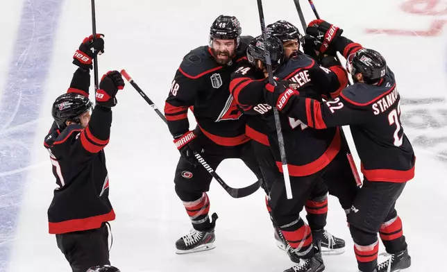 The Carolina Hurricanes players celebrate after the winning goal by Hurricanes' Seth Jarvis (24) against the Vegas Golden Knights during overtime in Game 2 of the NHL hockey Stanley Cup Final series in Raleigh, N.C., Thursday, June 4, 2026. (AP Photo/Ben McKeown)