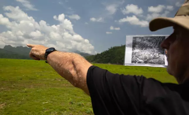 Andrew Snow, a researcher with the Thailand-Burma Railway Centre, uses historic aerial photographs from The National Archives in London to map out the layout of Nithe Station, a part of the infamous World War II "Death Railway," in Sangkhlaburi, Thailand on Saturday, May 30, 2026. (AP Photo/Anton L. Delgado)