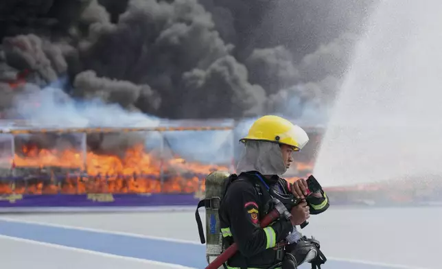 Firefighters spray water in front of illegal narcotics being burnt during a destruction ceremony marking the U.N.’s International Day Against Drug Abuse and Illicit Trafficking, on the outskirts of Yangon, Myanmar, Friday, June 26, 2026. (AP Photo/Thein Zaw)