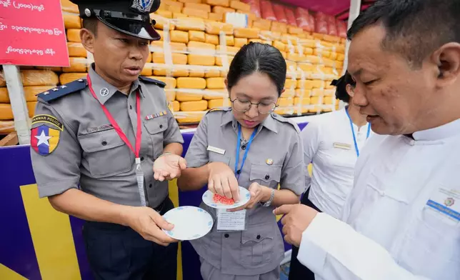Police officers explain about illegal narcotics to attendees during a destruction ceremony marking the U.N.’s International Day Against Drug Abuse and Illicit Trafficking, on the outskirts of Yangon, Myanmar, Friday, June 26, 2026. (AP Photo/Thein Zaw)