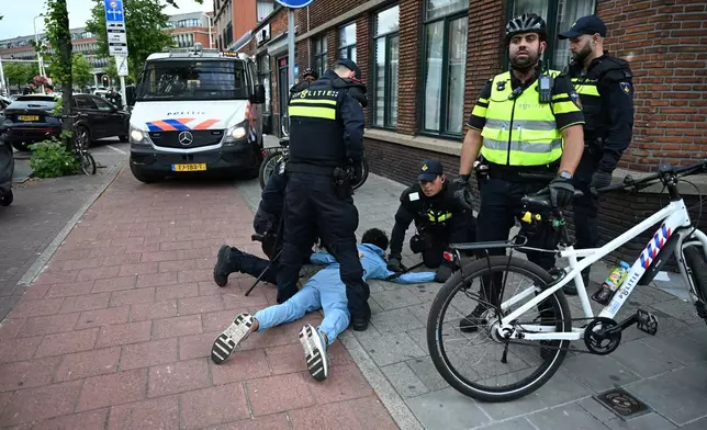 Police arrest a Moroccan fan after a World Cup soccer match between the Netherlands and Morocco in The Hague, Netherlands, Tuesday, June30, 2026. (AP Photo/Mouneb Taim)