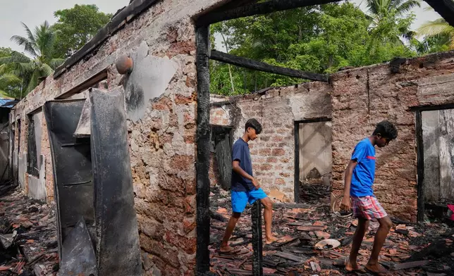 Villagers walk checking debris of the charred nursing home in Anguruwatota, Sri Lanka, Friday, June 5, 2026.(AP Photo/Eranga Jayawardena)