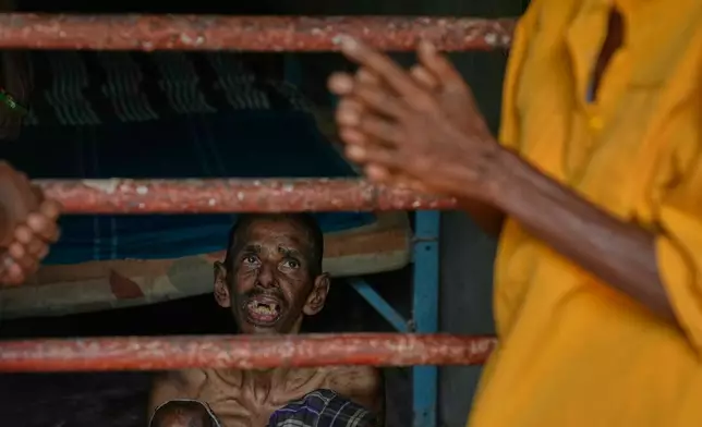 A resident looks at his family members as he sits inside his dormitory at a nursing home in Anguruwatota, Sri Lanka, Friday, June 5, 2026. (AP Photo/Eranga Jayawardena)