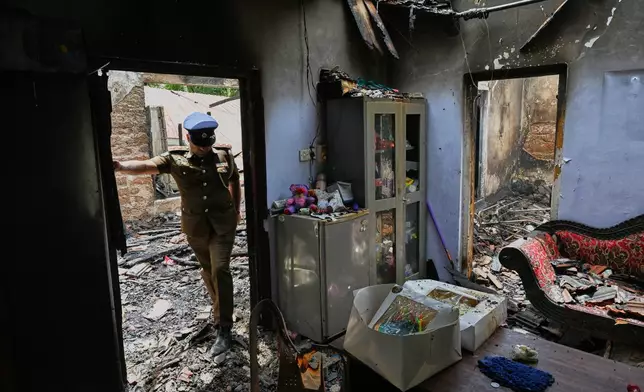 A Sri Lankan police officer inspects a charred elderly care home following an overnight fire in Anguruwatota, Sri Lanka, Thursday, June 4, 2026. (AP Photo)