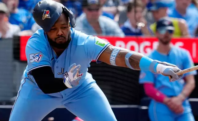 Toronto Blue Jays' Vladimir Guerrero Jr. (27) loses his helmet while swinging for a strike during in the fourth inning of a baseball game against the Baltimore Orioles, Saturday, June 6, 2026, in Toronto. (Frank Gunn/The Canadian Press via AP)
