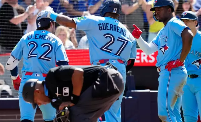 Toronto Blue Jays' Ernie Clement (22) is greeted by teammates after hitting a three-run home run during the third inning of a baseball game against the Baltimore Orioles, Saturday, June 6, 2026, in Toronto. (Frank Gunn/The Canadian Press via AP)