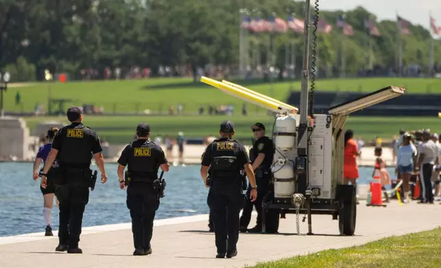 Oklahoma City Police Department officers, deputized to assist with local law enforcement for events around the 250th anniversary of the U.S., patrol near the area where sections of blue coating have peeled up in the Lincoln Memorial Reflecting Pool, Saturday, June 20, 2026, in Washington. (AP Photo/Mark Schiefelbein)