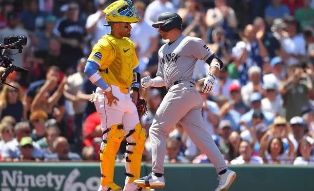 New York Yankees' Max Schuemann, right, scores on his home run in front of Boston Red Sox catcher Carlos Narváez, left, in the fifth inning of a baseball game, Saturday, June 27, 2026, in Boston. (AP Photo/Steven Senne)