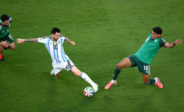 Argentina's Lionel Messi (10) battles for the ball with Algeria's Fares Chaibi (10) during the World Cup Group J soccer match between Argentina and Algeria in Kansas City, Mo., Tuesday, June 16, 2026. (AP Photo/Reed Hoffmann)