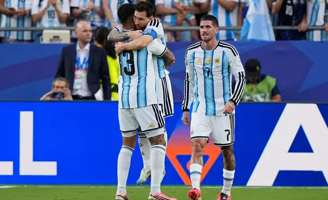 Argentina's Lionel Messi is congratulated by teammate Cristian Romero, left, as Rodrigo de Paul, right, watches after scoring his team's first goal during the World Cup Group J soccer match between Argentina and Algeria in Kansas City, Mo., Tuesday, June 16, 2026. (AP Photo/Charlie Riedel)