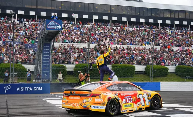 Denny Hamlin celebrates his win during a NASCAR Cup Series auto race at Pocono Raceway, Sunday, June 14, 2026, in Long Pond, Pa. (AP Photo/Derik Hamilton)