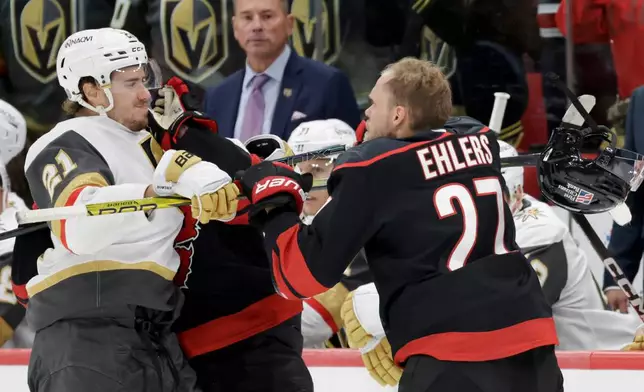 FILE - Vegas Golden Knights center Brett Howden (21) mixes it up with Carolina Hurricanes left wing Nikolaj Ehlers (27) during the third period of an NHL hockey game Oct. 28, 2025, in Raleigh, N.C. (AP Photo/Chris Seward, File)