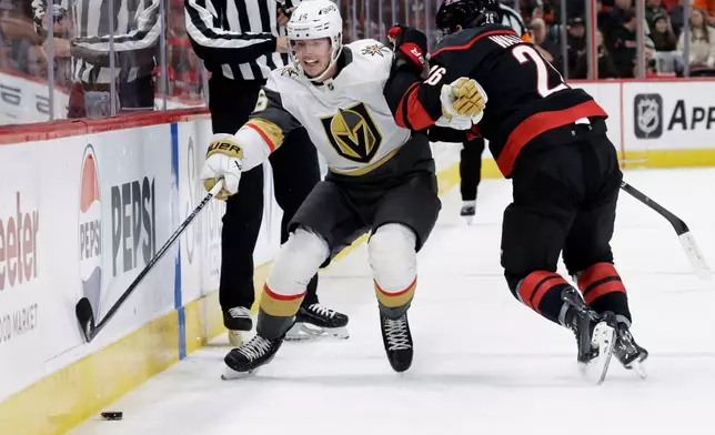 FILE - Vegas Golden Knights right wing Pavel Dorofeyev (16) and Carolina Hurricanes defenseman Sean Walker (26) vie for the puck during the first period of an NHL hockey game Oct. 28, 2025, in Raleigh, N.C. (AP Photo/Chris Seward, File)