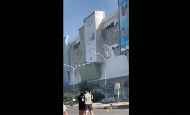 This image from a video shows people gathered outside a damaged building after a powerful earthquake in General Santos city on the island of Mindanao, Philippines Monday, June 8, 2026. (Ernesto Torres Jr via AP)