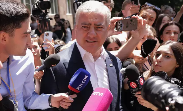 Russian-Armenian tycoon Samvel Karapetyan speaks to the media after voting at a polling station during a parliamentary election in Yerevan, Armenia, Sunday, June 7, 2026. (AP Photo/Anthony Pizzoferrato)