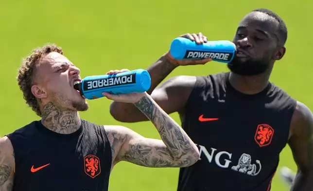 Netherlands' Noa Lang, left and Brian Brobbey take a hydration break during practice for the World Cup soccer tournament, Wednesday, June 10, 2026 in Riverside, Mo. (AP Photo/Charlie Riedel)