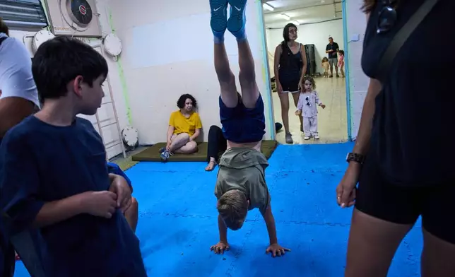 People take shelter as air raid sirens warning of incoming Iranian missiles in Ramat Gan, Israel, Monday, June 8, 2026. (AP Photo/Oded Balilty)