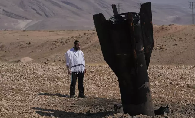 A man looks at the wreckage of an Iranian missile that landed near the West Bank city of Jericho Monday, June 8, 2026. (AP Photo/Mahmoud Illean)